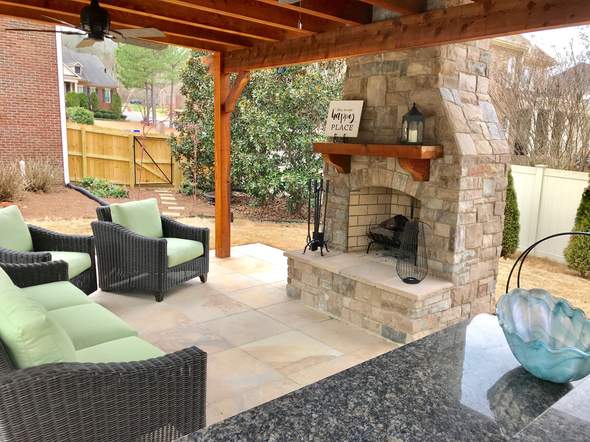 Work from home outdoor space-Covered patio with lounge seating and a ceiling fan, with a fireplace as the focal point.